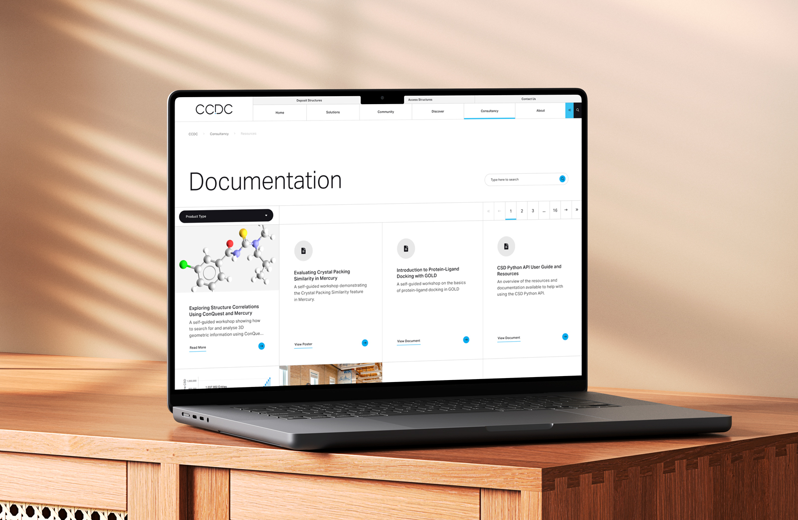 A webpage on a laptop showing software documentation, filters, pagination and different document types