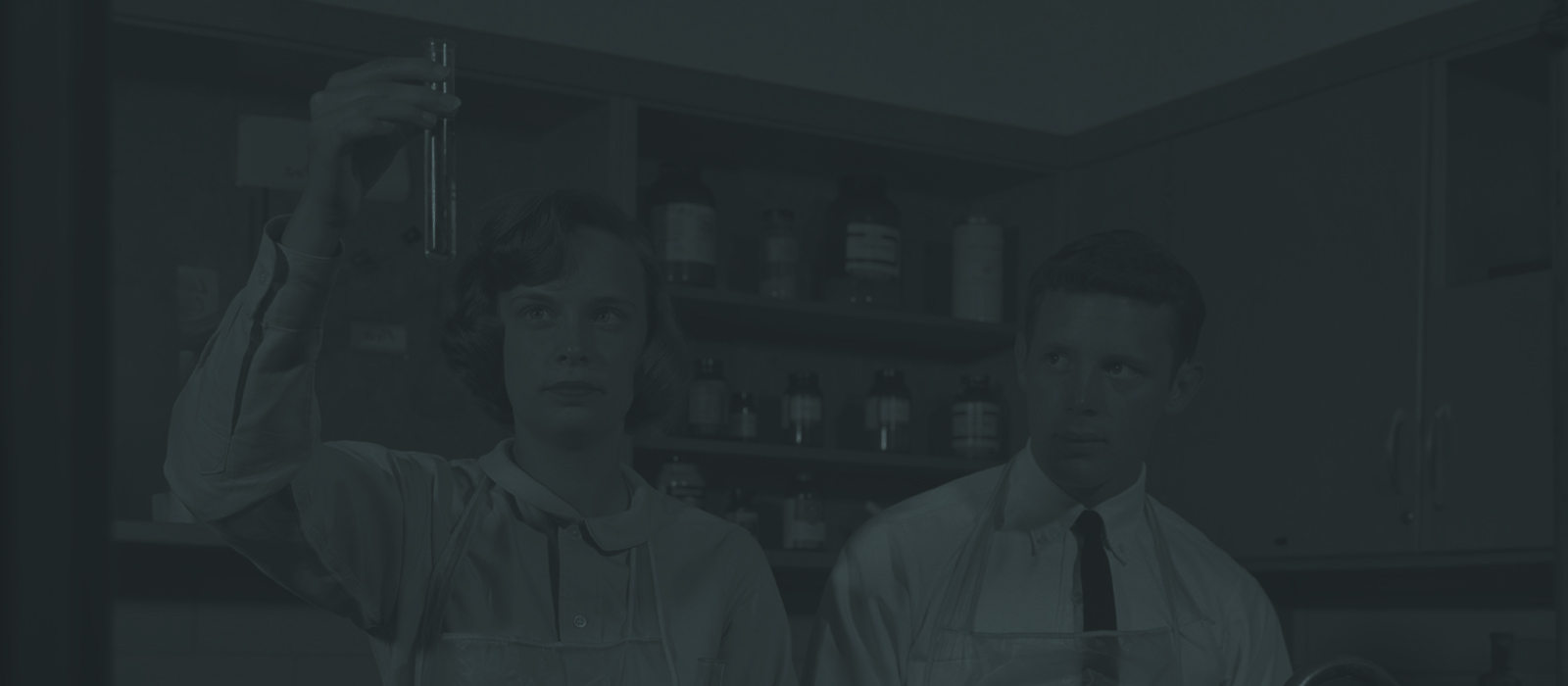 vintage photo of scientists in a lab examining a test tube