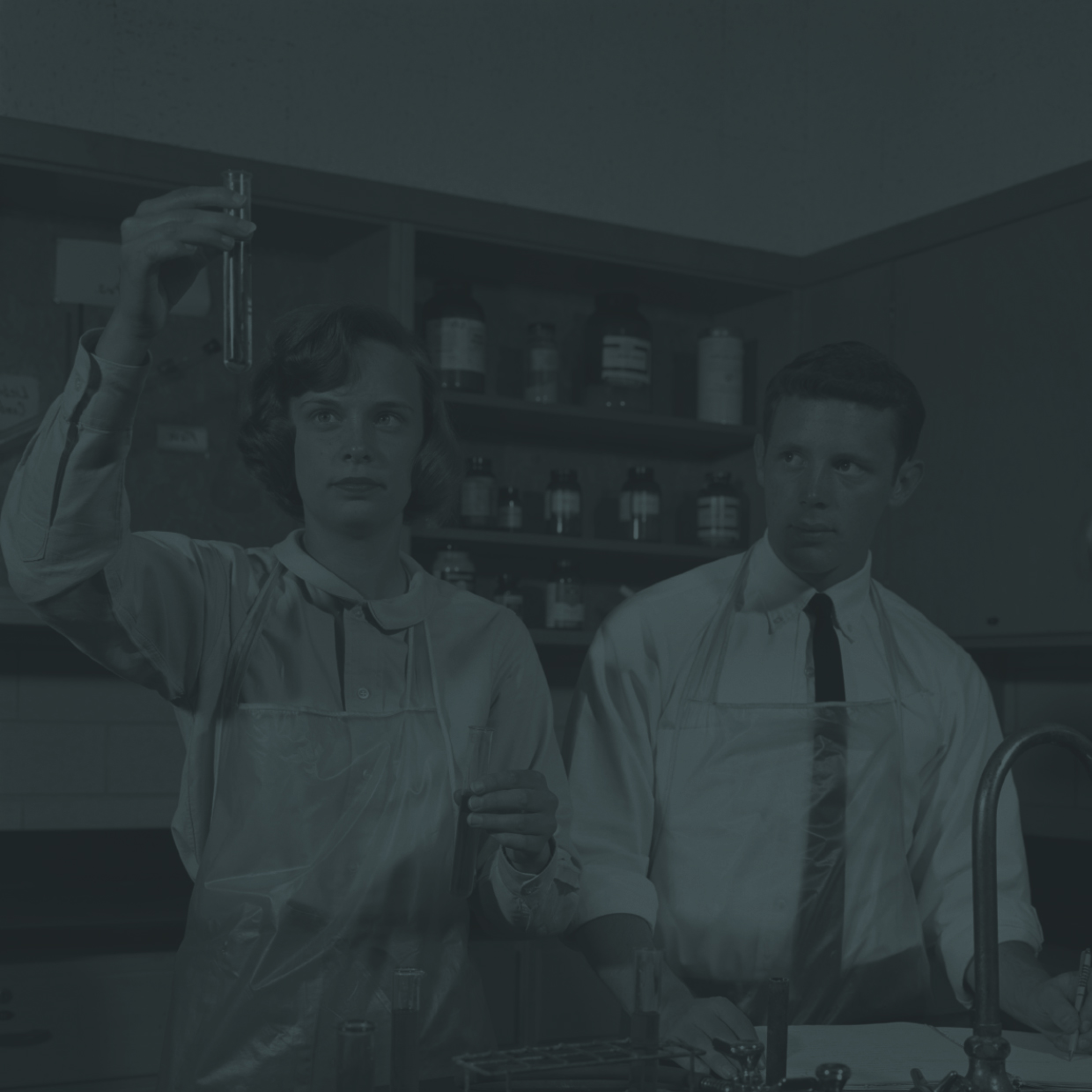 vintage photo of scientists in a lab examining a test tube