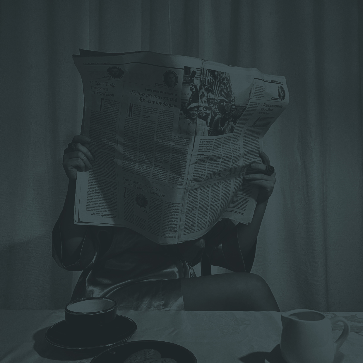 Lady reading a newspaper at breakfast